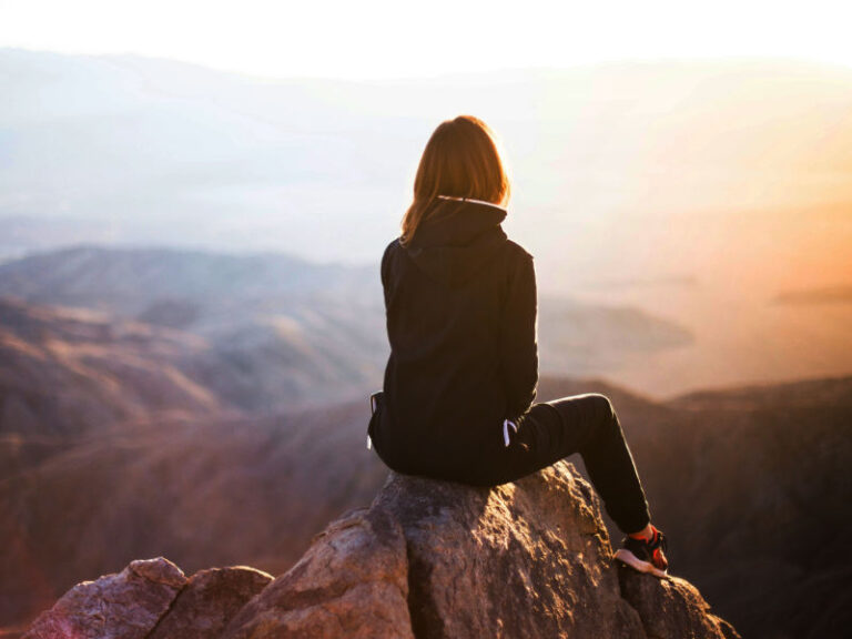 Woman on top of a mountain.